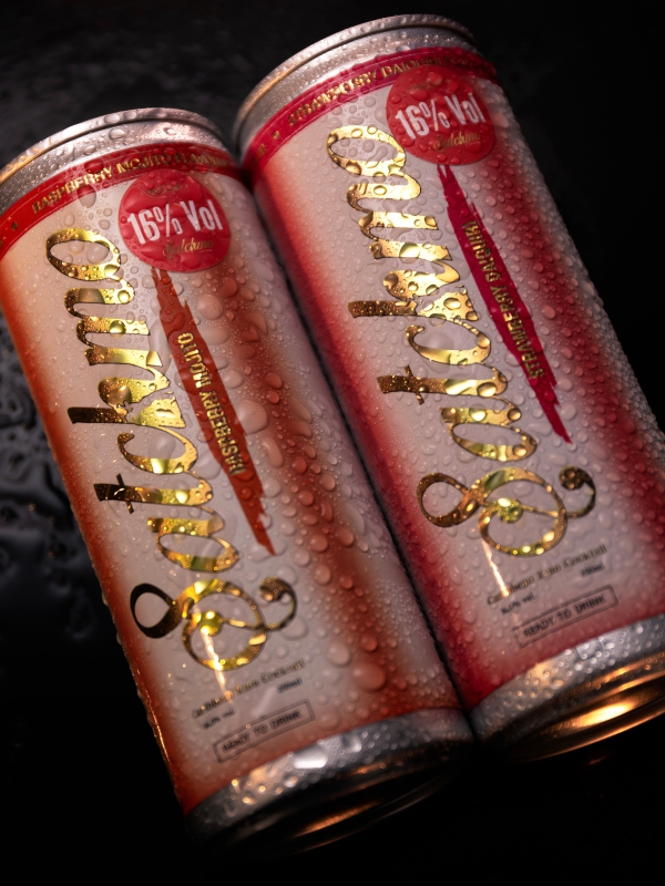 Two Gold And Red Beverage Cans With Satshmo Branding And Condensation Droplets.